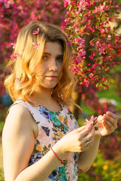 istock brunette girl poses against a blooming apple tree 1497718020