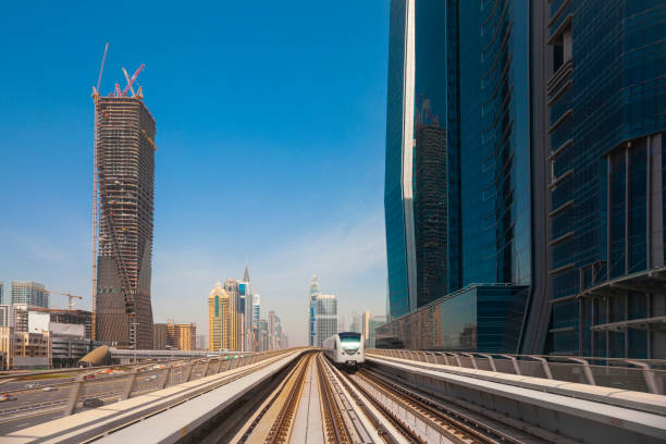 modern skyscrapers along the metro line in dubai, uae - driverless train imagens e fotografias de stock