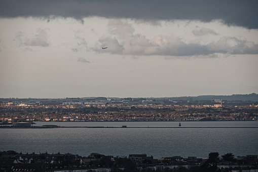 Dublin, Ireland - February 2023 - A view of Dublin Bay and Dublin's Northside with Airplane overhead
