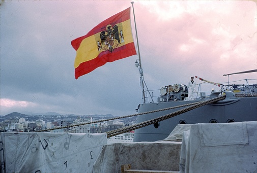 Las Palmas, Gran Canaria, Spain, 1968. The battle cruiser Canarias (rear) in the port of Las Palmas. Also: a sailor on duty.