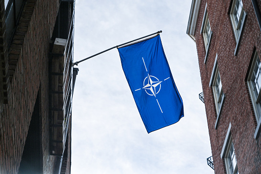 Nato flag between the buildings. Photographed on the streets of Philadelphia city on 4/22/23