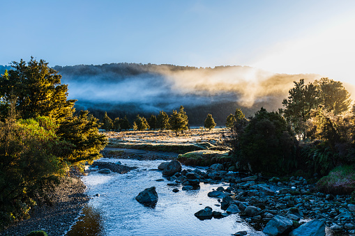 Nature scene of river and foggy mountains in the morning. Photographed in New Zealand.
