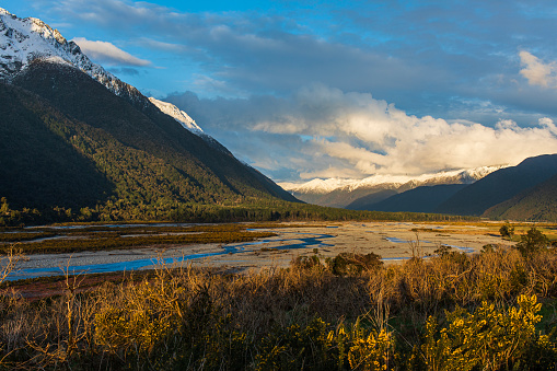 Nature scene of a river winding through the valley and mountains during sunset. Photographed in New Zealand.