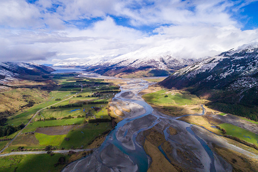 Aerial perspective of river braid system from glacial runoff with scenic snow covered mountains. Shot in New Zealand.