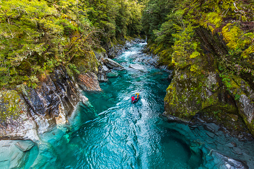Kayaking down river rapids in the mountains of New Zealand.