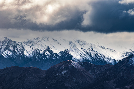 Breathtaking nature scene of valley and tall snow covered mountains with dramatic clouds. Photographed in New Zealand.