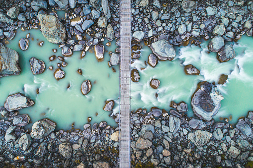 Directly above a suspension bridge over glacial river in the mountains. Photographed in New Zealand.