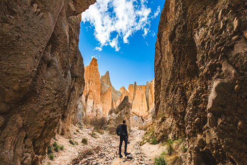 Man standing looking up at unique rock formation pinnacles in New Zealand