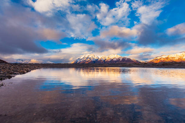 istock Reflection of snow capped mountain range on a still lake at sunset 1497733138
