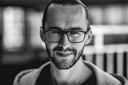 Black and white photography with beard person. Male portrait of a handsome man with eyeglasses. Lifestyle photo with nice people.
