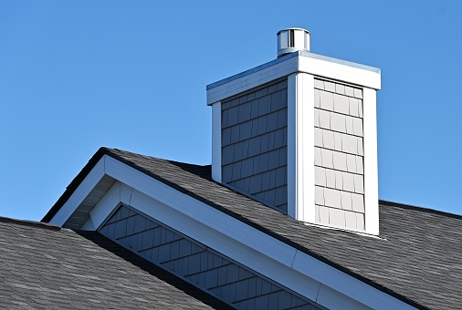 Chimney with siding on the roof.