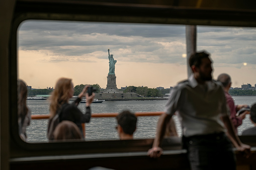 Group of Tourists Watching Statue of Liberty from the Ferry. New York City.