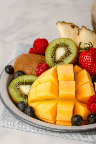 istock Tropical fruits on plate on concrete background. 1497742286
