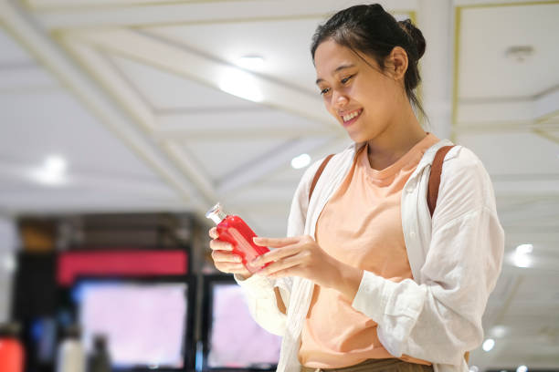 デパートで買う香水を選ぶ笑顔のインドネシア人女性 - asian ethnicity women shopping mall perfume ストックフォトと画像