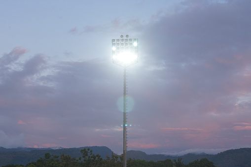 a stadium lamp start to shine at the top of a mountain
