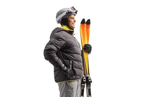 Profile shot of a man holding a pair of skis isolated on white background