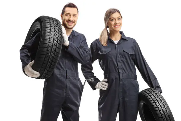 Male and female car mechanic workers carrying tires isolated on white background