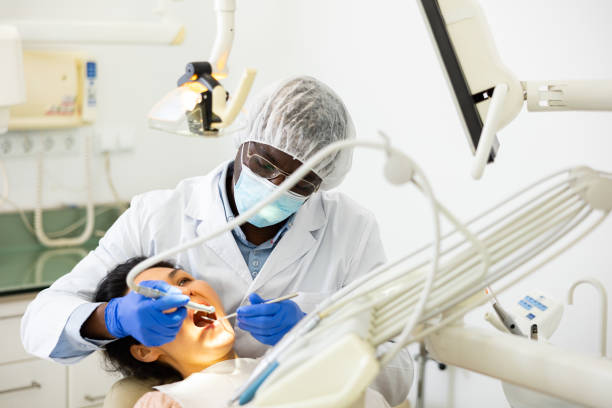 istock Male dentist using tools for tooth repairing on woman patient 1497757855