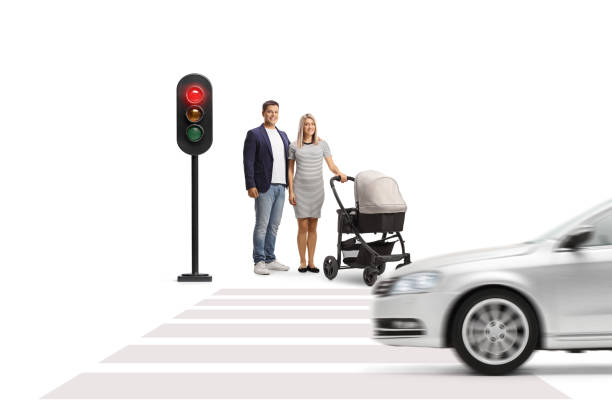 Couple with a baby stroller waiting at traffic lights