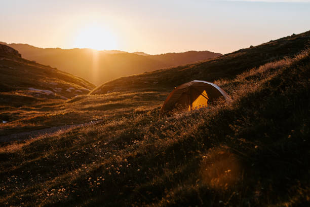 istock Morning sunrise over a valley and small tent 1497762595