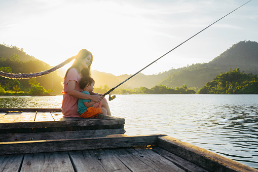Shot of a mother and son fishing together at terusan mande, painan, west sumatra