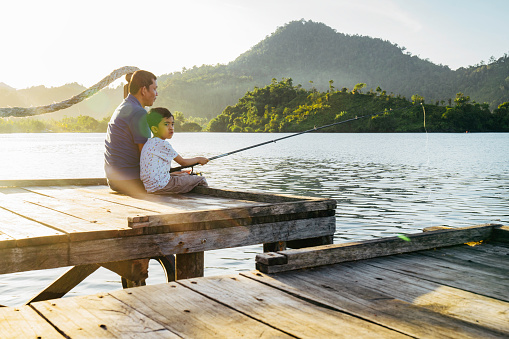 Shot of a father and son fishing together at terusan mande, painan, west sumatra