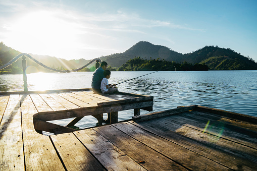 Shot of a father and son fishing together at terusan mande, painan, west sumatra