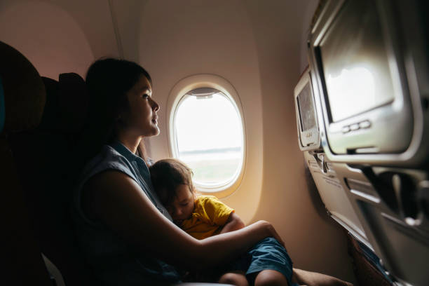 istock mother holding baby son on airplane 1497764622