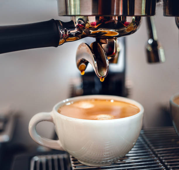 istock Espresso coffee extraction from a professional coffee machine with a bottomless filter, Close-up of a coffee drop  from the coffee machine 1497768073
