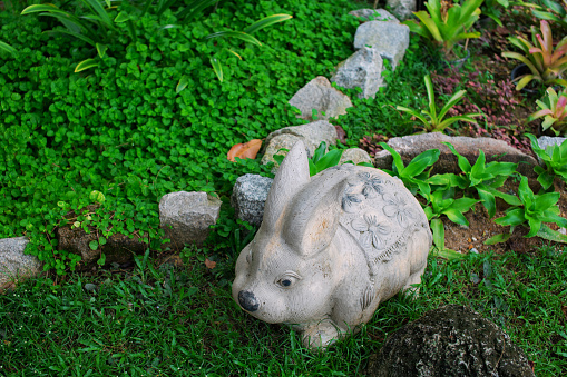 The garden is beautifully decorated with a tiered stone setting consisting of plants and signs and rabbit statues.