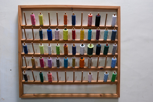 Rows of colorful sewing thread on the wall