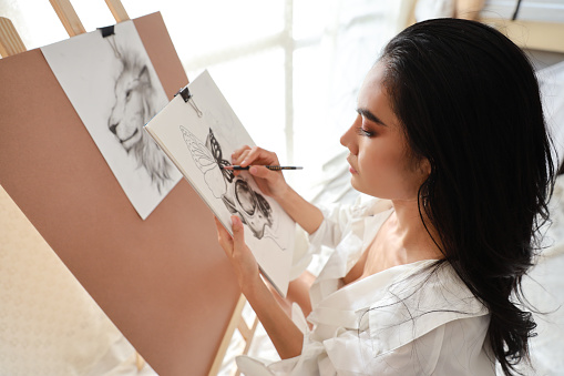 close up woman artist in white shirt drawing picture with pencil (woman lifestyle concept)