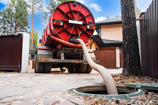 Sewer pumping machine. Septic truck. Pipe in the drainage pit. Pumping out sewage from a septic tank. Septic tank service