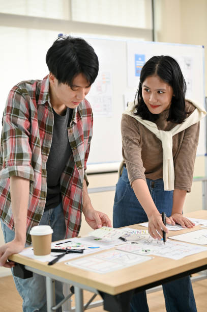 istock A male website developer is talking and planning a new project with a female colleague 1497774912