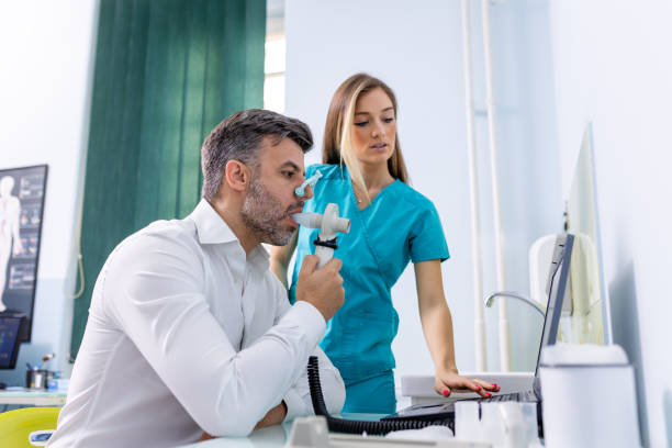 Adult man testing breathing function by spirometry having health problem. Diagnosis of respiratory function in pulmonary disease. Adult man testing breathing function by spirometry having health problem. Diagnosis of respiratory function in pulmonary disease. asthma stock pictures, royalty-free photos & images