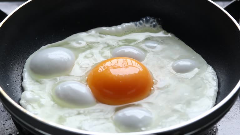 Cracked raw egg into hot frying pan