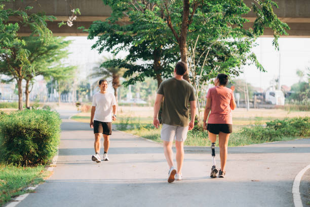 istock Woman exercising in a park with a friend providing support while using a prosthetic leg. People jogging side by side outside in a park. Female walking and exercise works out outside. 1497791169