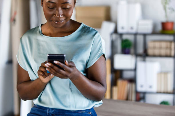 istock Young woman taking a break from work at the office and responding to a text message 1497793955