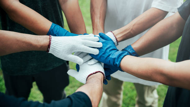 istock teamwork unity concept A group of friends joined hands in a campaign to help the community collect garbage. To conserve nature and the environment, love the world 1497797738