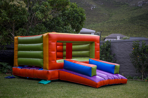 A jumping castle in a garden for a kids party.