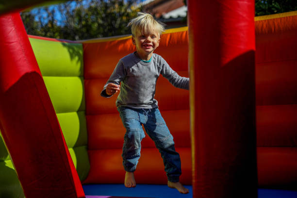 istock A young boy plays on a jumping castle for his birthday. 1497797865