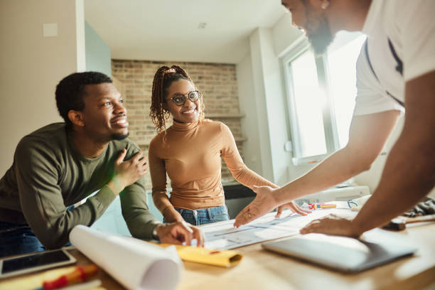 istock Happy African American couple talking about plans with their manual worker. 1497798470