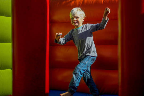 istock A young boy plays on a jumping castle for his birthday. 1497798482