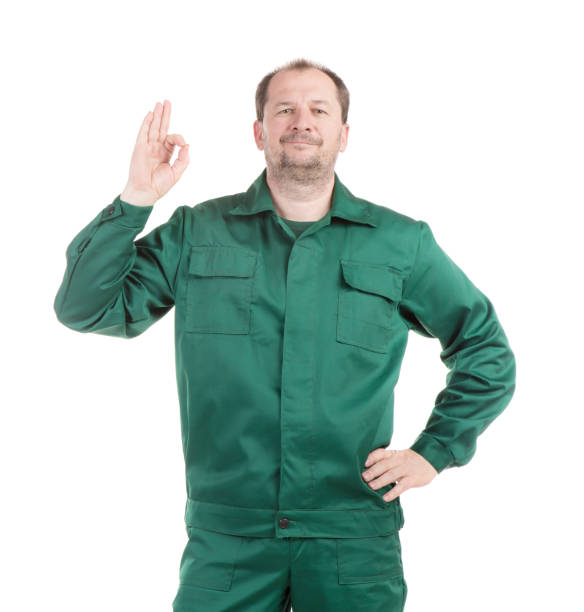 A man in a green work full suit shows the \