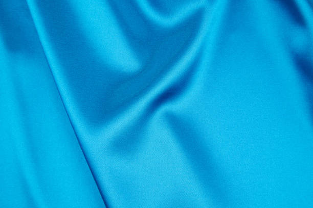 istock Soft folds of blue silk cloth. 1497799392