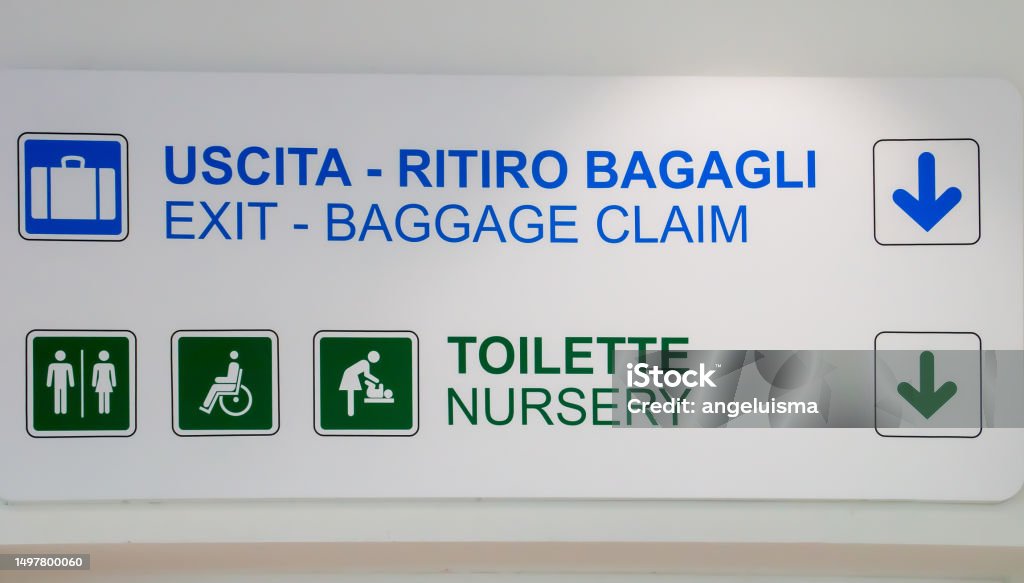 Information sign at the Bari-Palese airport, Aeroporto Internazionale di Bari-Karol Wojtyla, Italy. Signage for the location of the toilet, baggage claim and departure in English and Italian. Accessibility Stock Photo