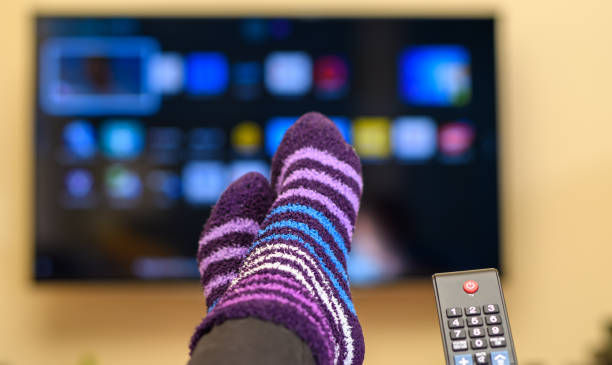 assistindo tv em casa, de meias quentes, controle remoto na mão - tube socks - fotografias e filmes do acervo