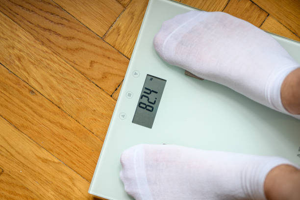 istock Weight loss, a man standing on an electronic weight scale 1497801763