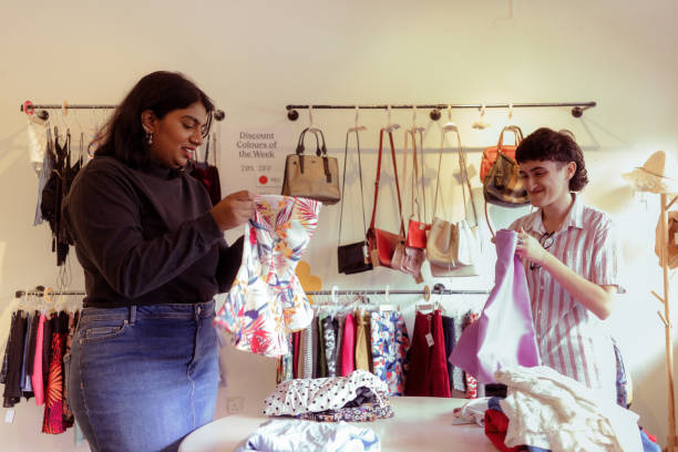 istock Two Multicultural Coworker Shop Owner Sorting Secondhand Clothes in Store 1497801804