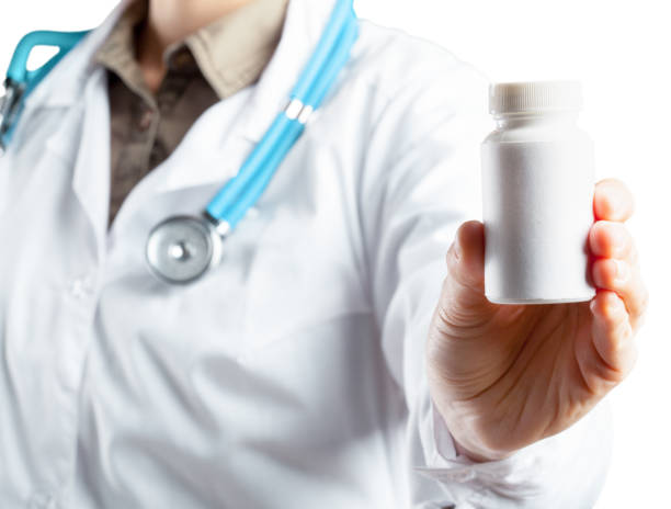 istock Female doctor holding a pills. Isolated on white. 1497803483